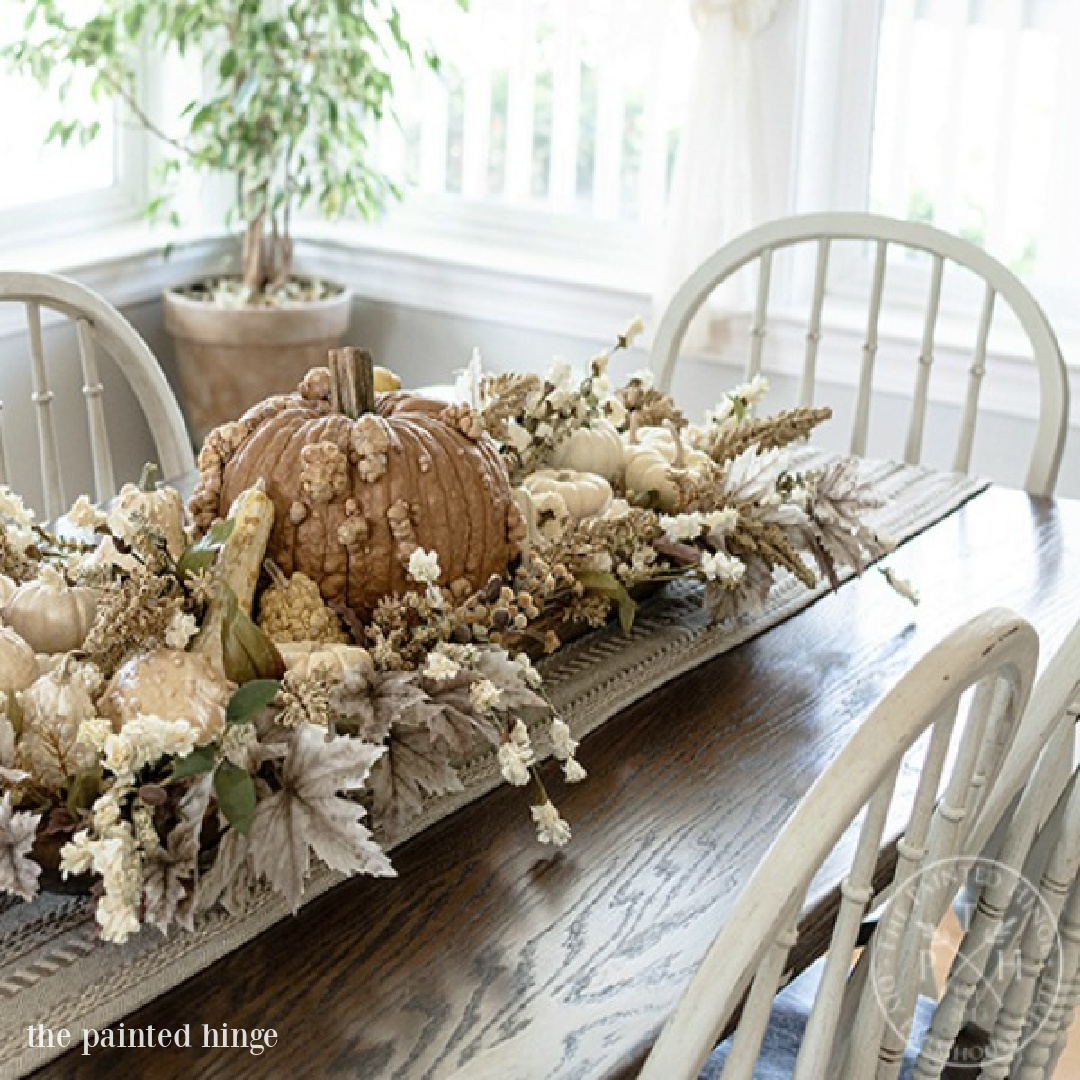 Soothing, serene, and calm colors in this rustic elegant farmhouse style pumpkin centerpiece by The Painted Hinge. Serene French Farmhouse Fall Decor Photos ahead! #fallcenterpiece #frenchcountry #frenchfarmhouse #tablescape #autumndecor