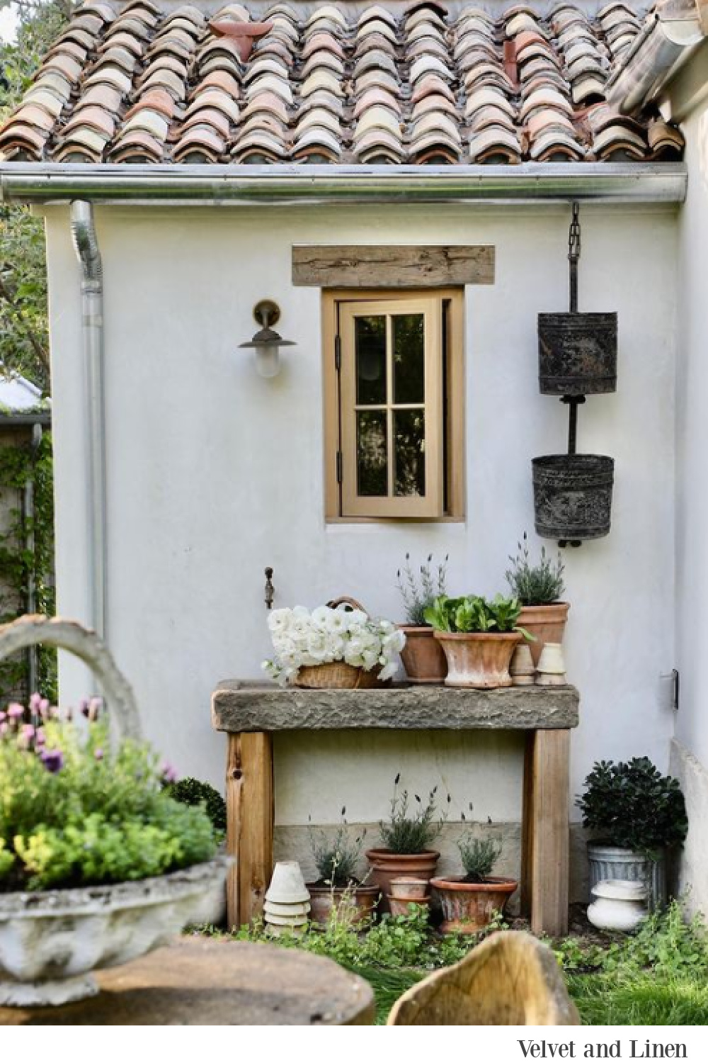 French country style at Patina Farm where pots are gathered on a potting shed - Velvet and Linen.