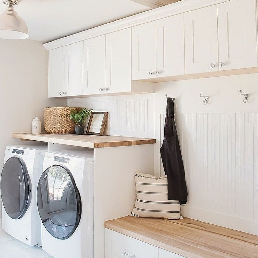 Cloud White (Benjamin Moore) paint color in laundry room mud room with bench and hooks - @makingitinthemountains. #cloudwhite #whitepaintcolors
