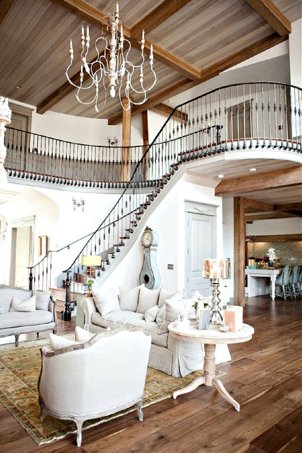 French country great room with magnificent wrought iron staircase and white decor - Desiree Ashworth. #frenchcountry #greatrooms