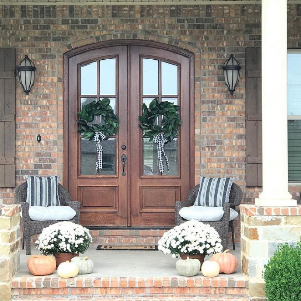 Porch with fall decor, mums, wreaths with ribbon, and pumpkins - Maven Haven. #fallporch #fallfrontdoor