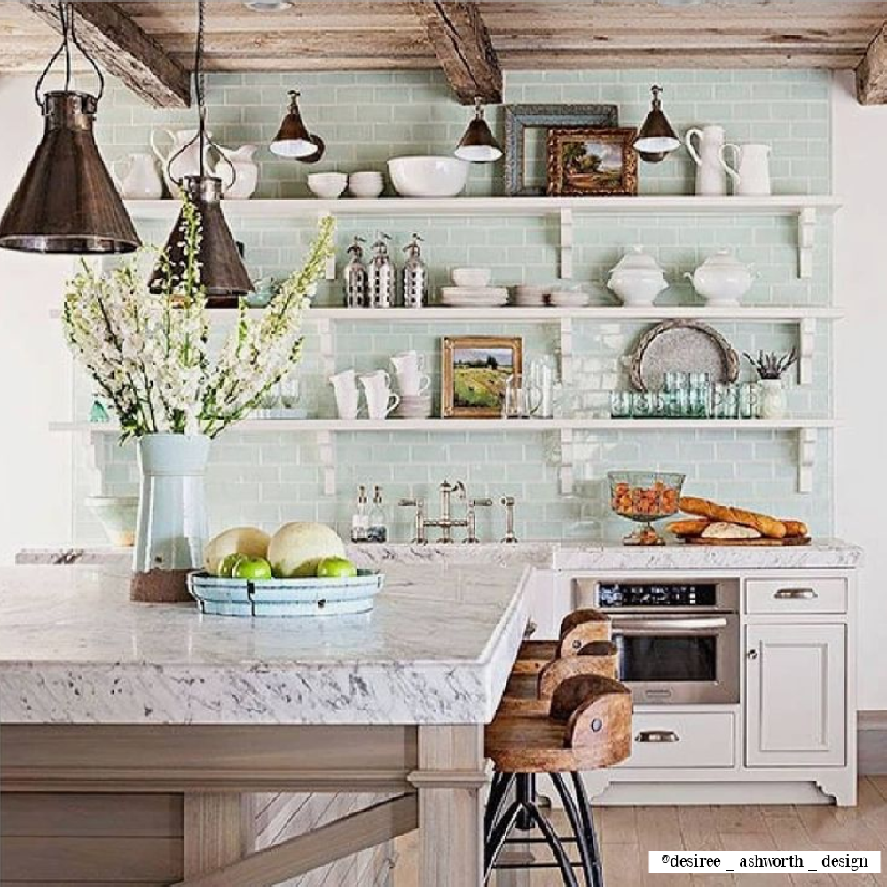 Light green accents in a rustic French farmhouse kitchen by Desiree Ashworth Design. #frenchkitchen #frenchfarmhouse #openshelves #subwaytile