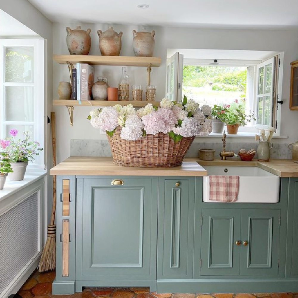 Green Smoke (Farrow & Ball) paint color on cabinets in a rustic elegant French farmhouse kitchen by Vivi et Margot. #frenchkitchen #greensmoke #paintcolors #frenchcountrykitchen