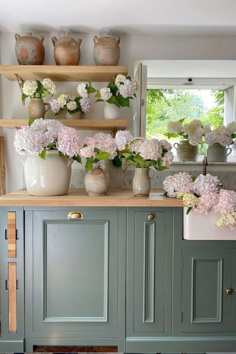 Green Smoke (Farrow & Ball) paint color on cabinets in a rustic elegant French farmhouse kitchen by Vivi et Margot. #frenchkitchen #greensmoke #paintcolors #frenchcountrykitchen