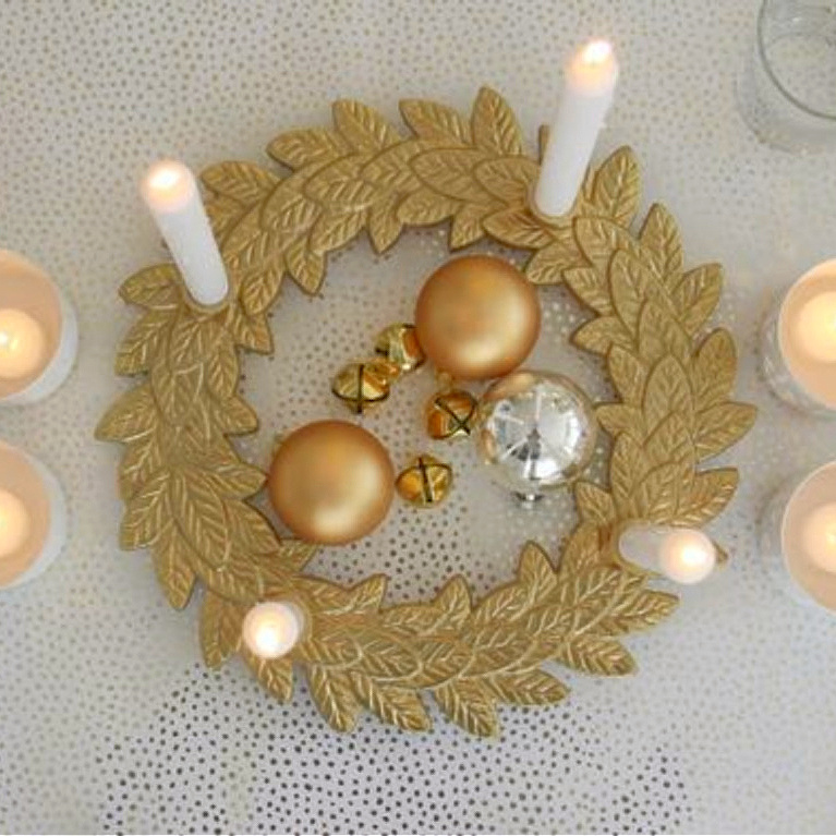 My gold advent wreath with candles lit on the table for Christmas - Hello Lovely Studio. #goldandwhite #christmasdecor #adventwreath