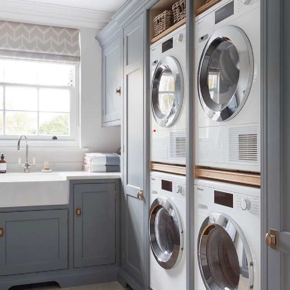 Beautiful laundry room design with Dutch door, wall of cabinets, grey cabinets and farm sink. #laundryroom #interiordesign