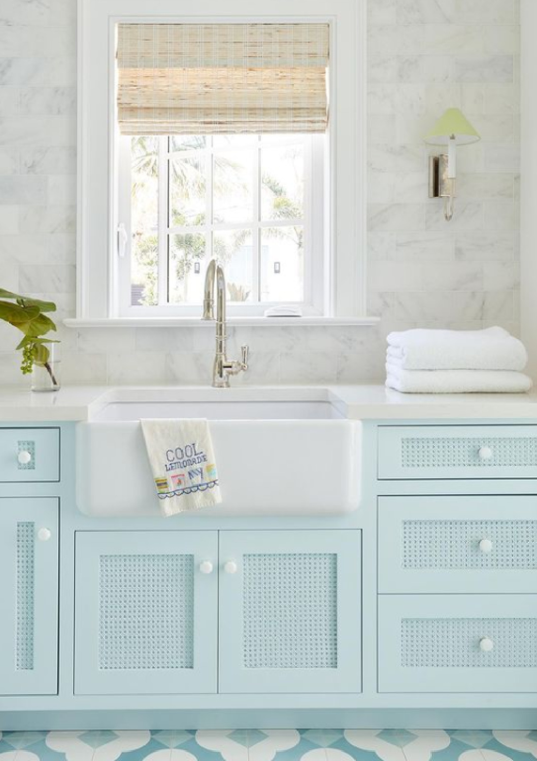 Pastel blue turquoise laundry room cabinets with marble subway backsplash, farm sink, and whimsical tile floor - KaraMillerInteriors. #laundryroom #turquoise #pasteldecor