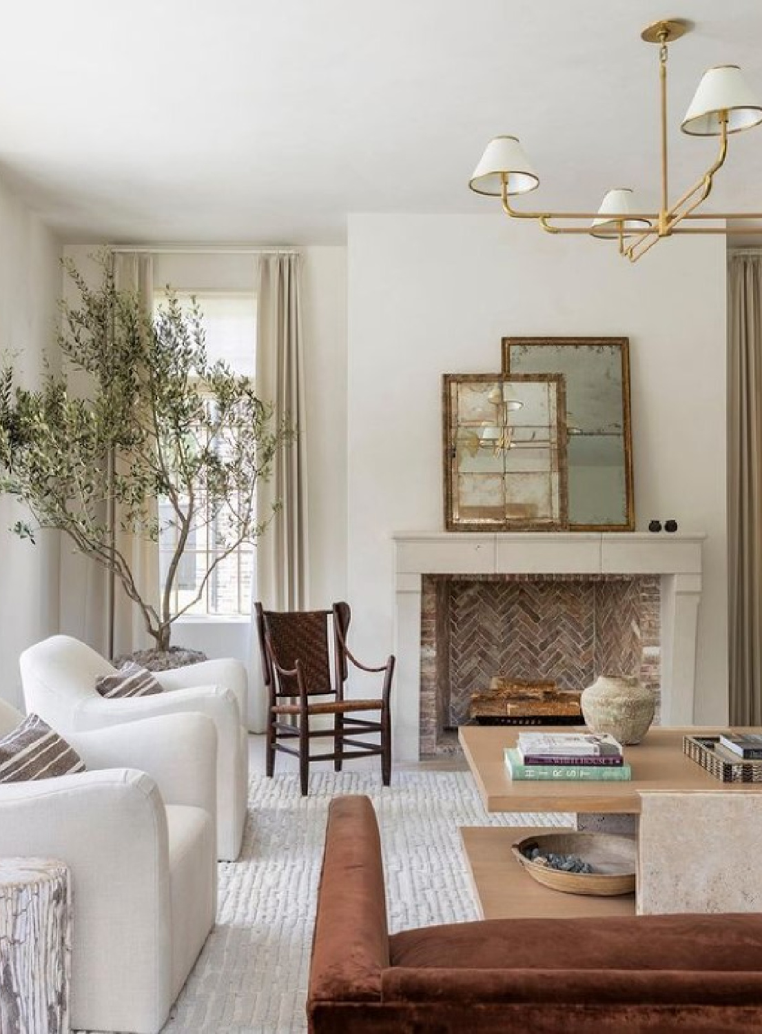 Elegant French country inspired living room by Marie Flanigan Interiors. Limestone fireplace, neutral colors, gilded lighting, and potted tree. #livingrooms #elegantlivingroom