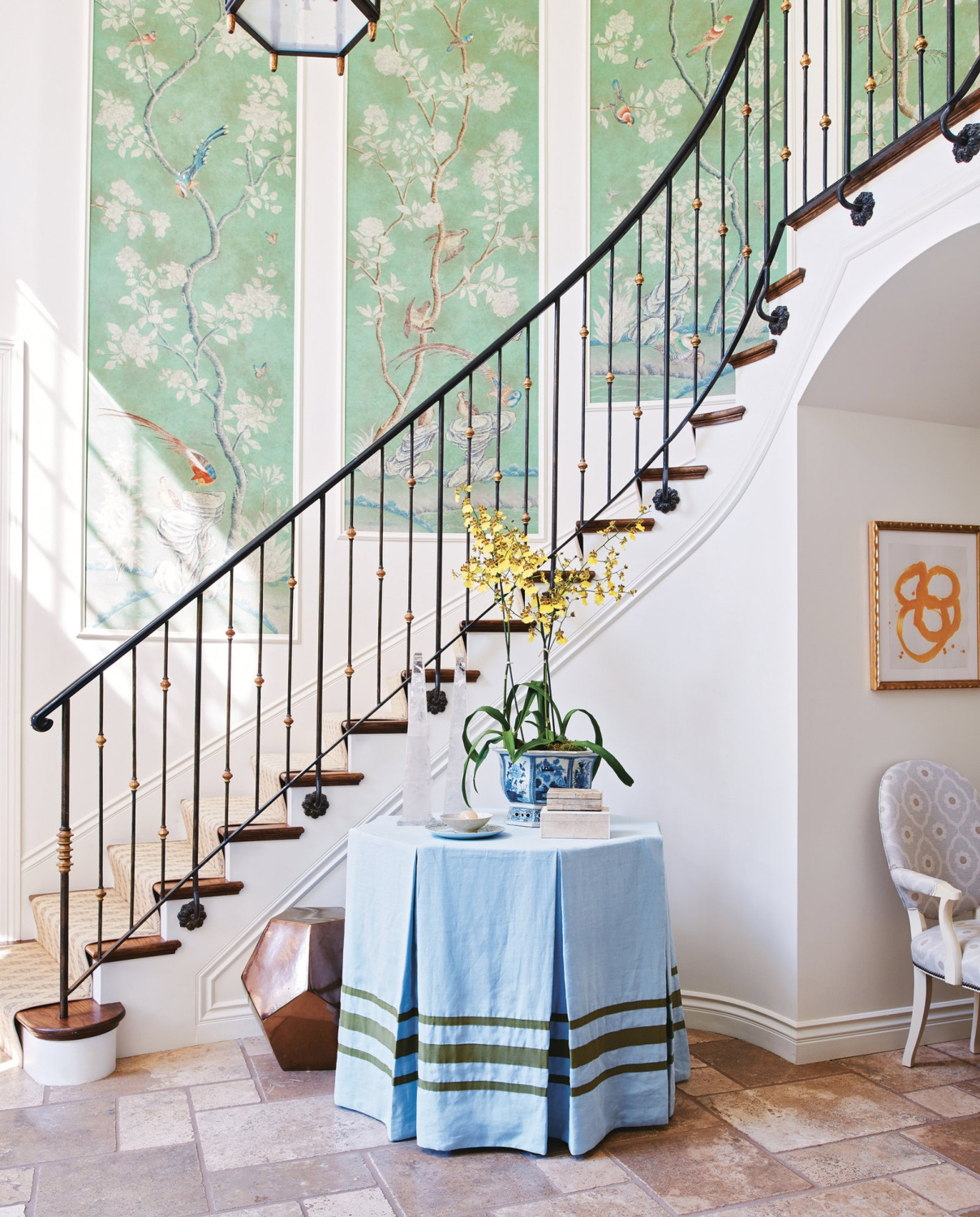 Mark Sikes designed entry with wrought iron staircase and skirted round table. #traditionalstyle #entry #interiordesign