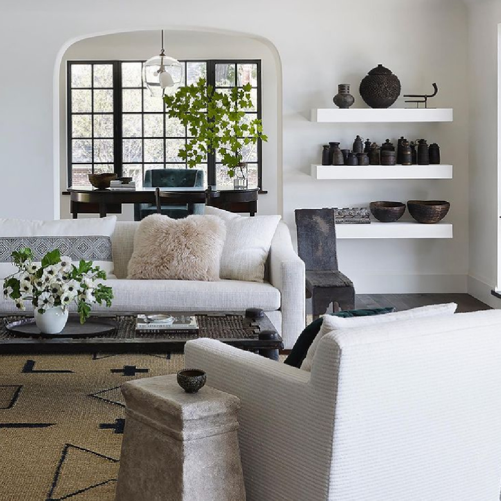 Exquisite modern rustic living room by Michael del Piero with floating shelves, black pottery, and neutral furnishings. #mdpgooddesign #modernrustic #interiordesign