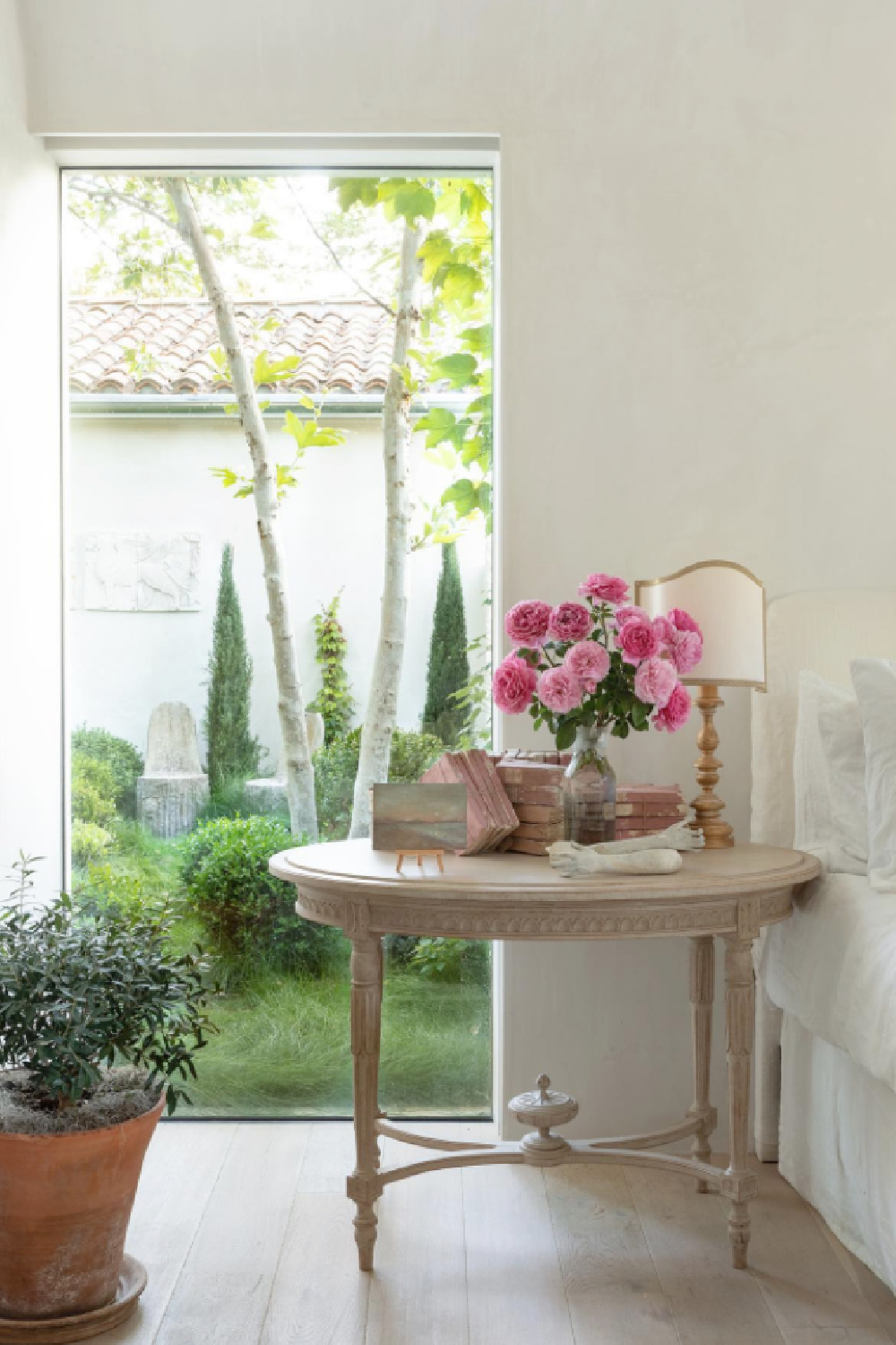 Serene bedroom with antique bedside table at Patina Farm - Brooke Giannetti of Velvet and Linen. #frenchfarmhouse #bedrooms #patinafarm