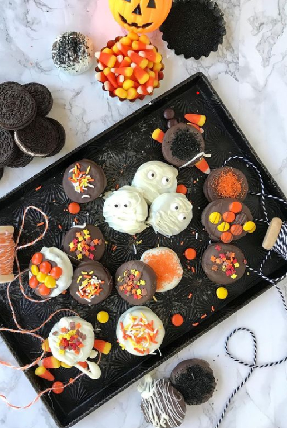 Halloween goodies and treats on a black tray with orange baker's twine - PineconesandAcorns. #halloween #tablescape #sweetsboard