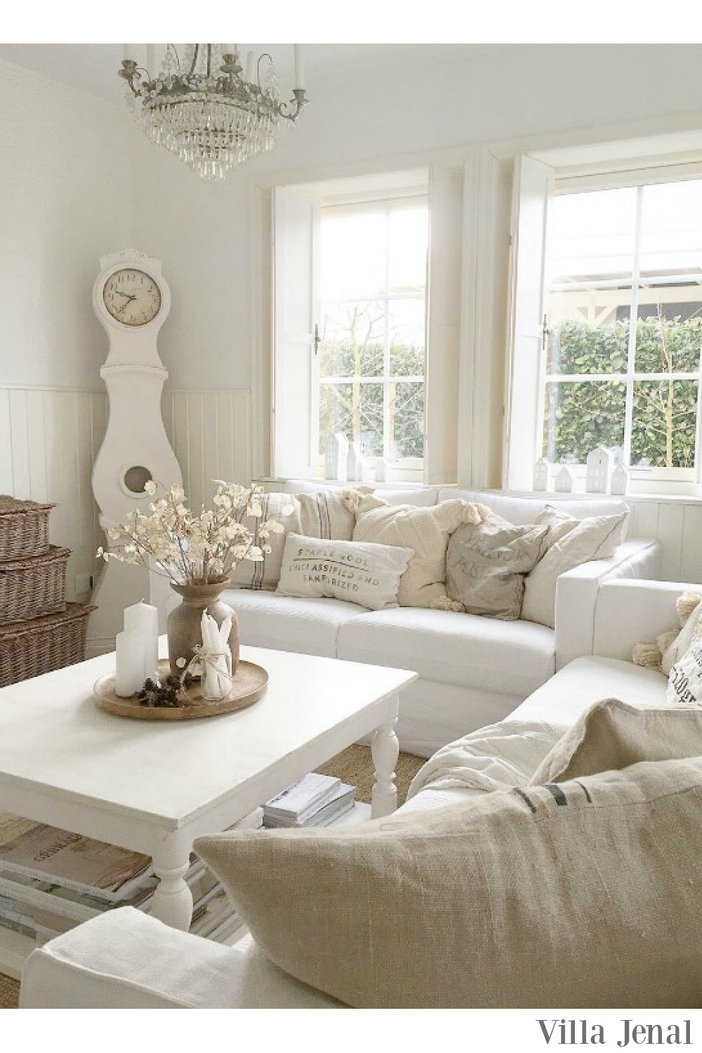 Cozy warm white Swedish living room with all white decor and Mora clock - Villa Jenal. #whitelivingroom #whitedecor #scandistyle