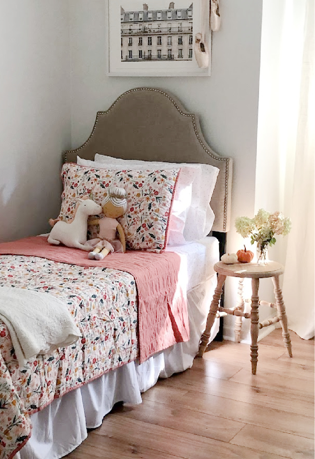 White walls painted BM OC-150. Floral quilt with dusty rose in a sweet bedroom with fall light - Hello Lovely Studio.