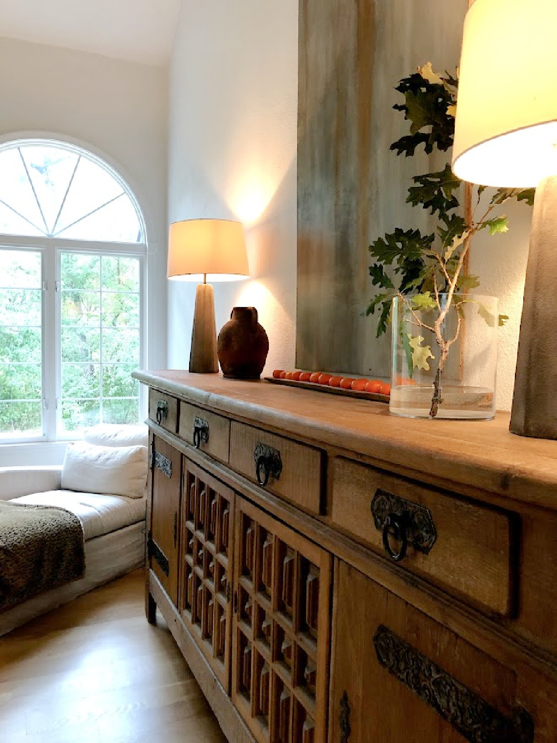 Rustic antique Belgian sideboard with oak branch in vase in early fall - Hello Lovely Studio.