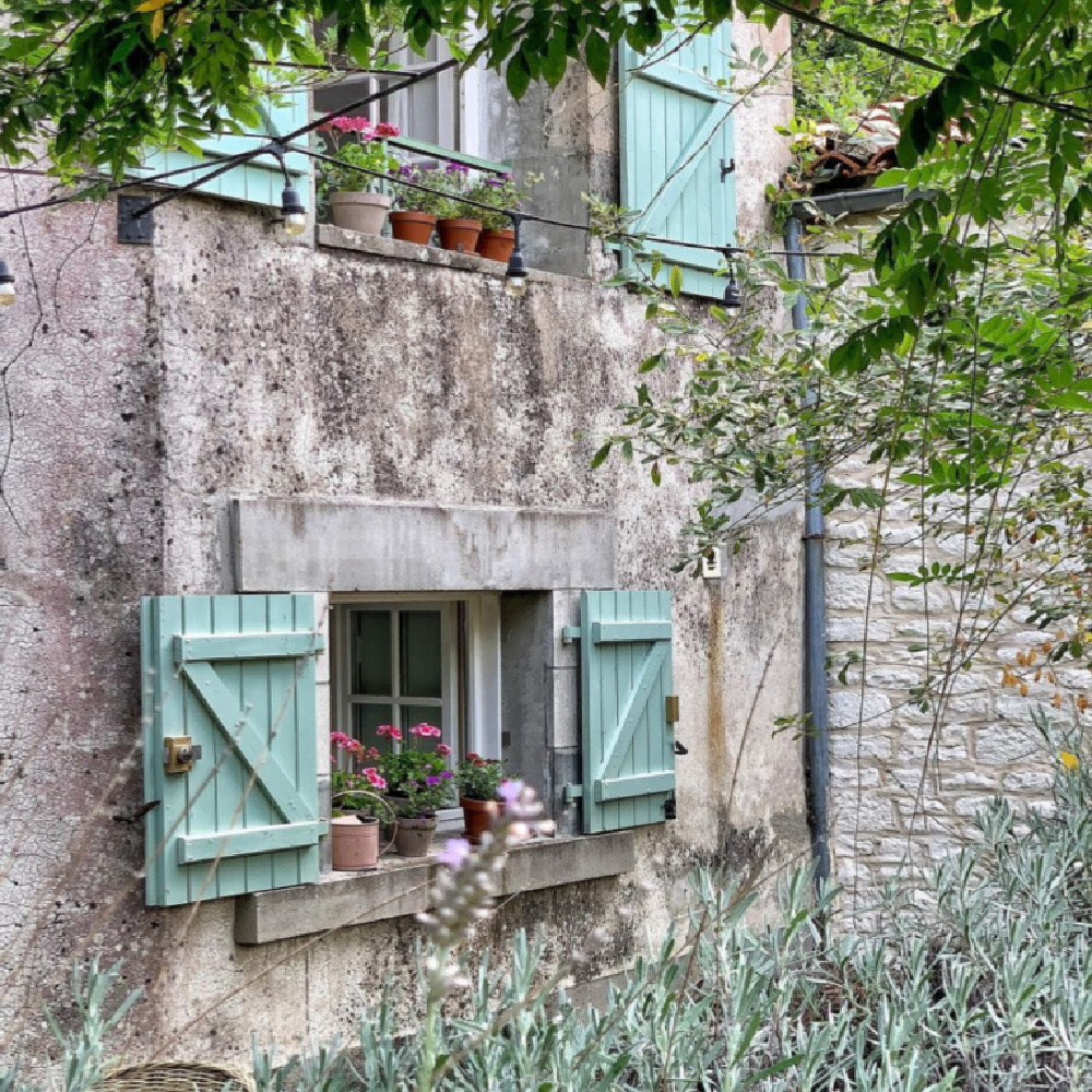 Rustic exterior of a French farmhouse near Bordeaux with green (Tollens) shutters and a darling window sill - Vivi et Margot. #frenchfarmhouse #exteriors #rusticcottage #frenchcottages #oldworldstyle #greenshutters #cottageinFrance