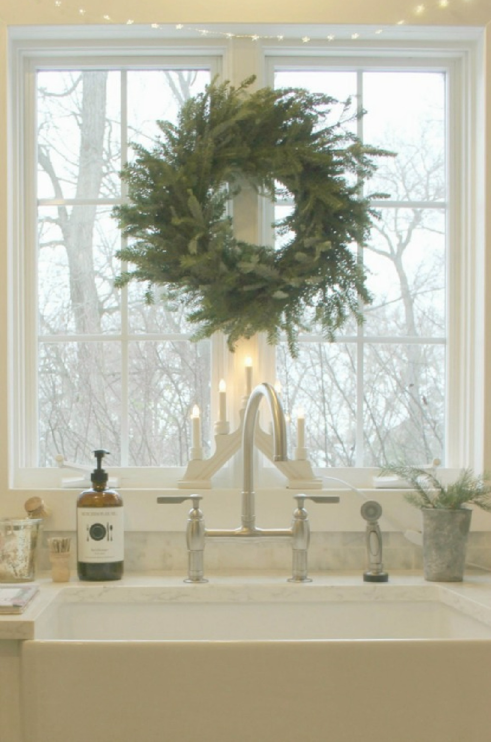 My Christmas kitchen with Scandinavian style and a fresh wreath over farm sink - Hello Lovely Studio. #swedishchristmas