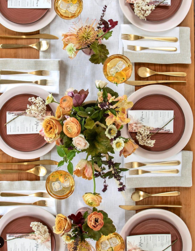 Neutral Thanksgiving or fall tablescape with rust accents, linen, and fresh florals - @tableanddine. #falltablescape #thanksgivingtable #centerpieces