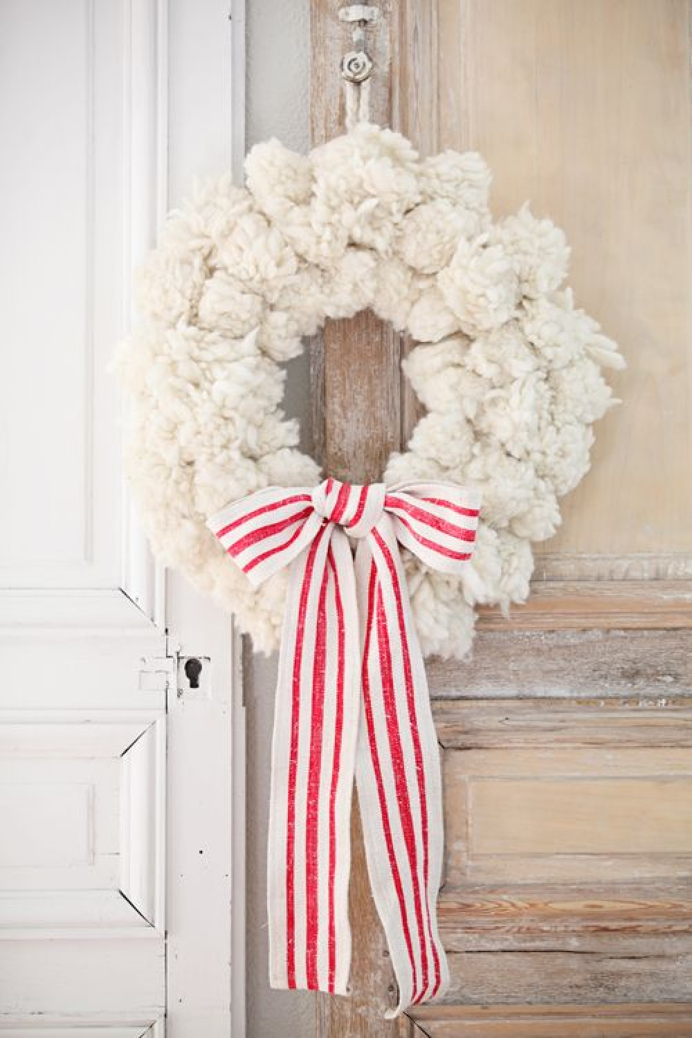 Charming shabby chic white pom pom Christmas wreath with red and white grainsack ribbon -Dreamy Whites. #pompomwreath #christmaswreath #frenchchristmas