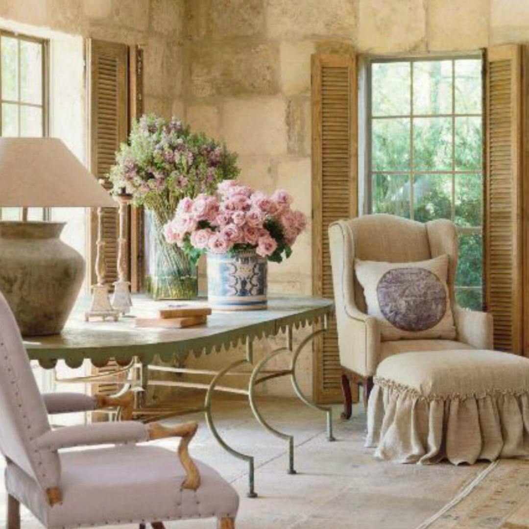 French farmhouse living room with antiques, limestone, and shutters. Design by Pamela Pierce. #chateaudomingue #frenchcountry #reclaimedstone 