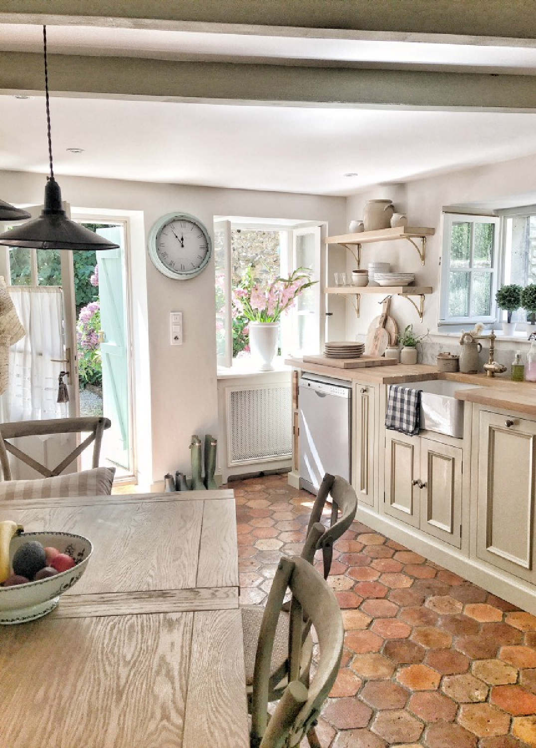 French farmhouse kitchen with putty colored cabinets, butcher block, farm sink, terracotta hex tile, and open shelving - Vivi et Margot.