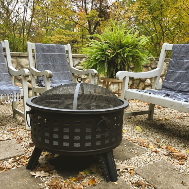 Wood burning fire pit in our French country courtyard with pea gravel is the perfect little addition to enjoy roasted marshmallows and family time. #firepit #woodburningfirepit #outdoordecor #patiodecor #hellolovelystudio