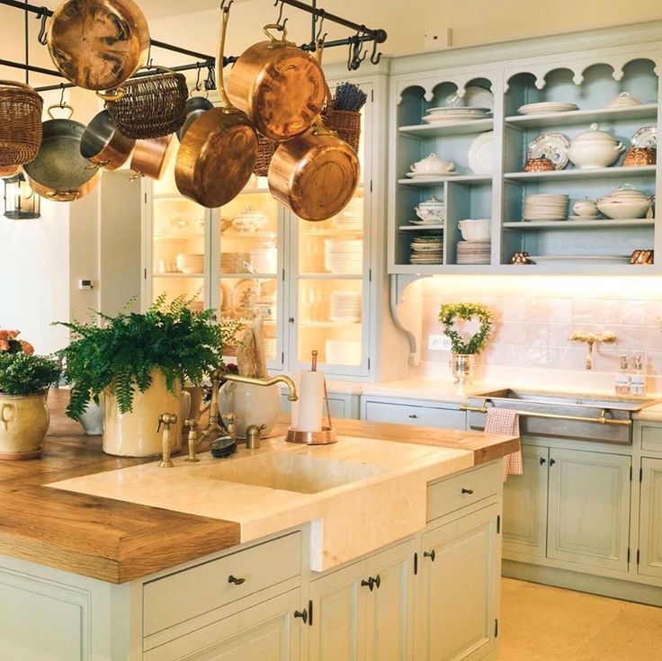 French farmhouse kitchen in Provence with light blue cabinets and copper pots from E. Dehllerin - @provencepoirers. #frenchkitchen #frenchfarmhouse #frenchchateau #copperpots #frenchfarmhousekitchen #lightblue #provencekitchen #provencepoirers