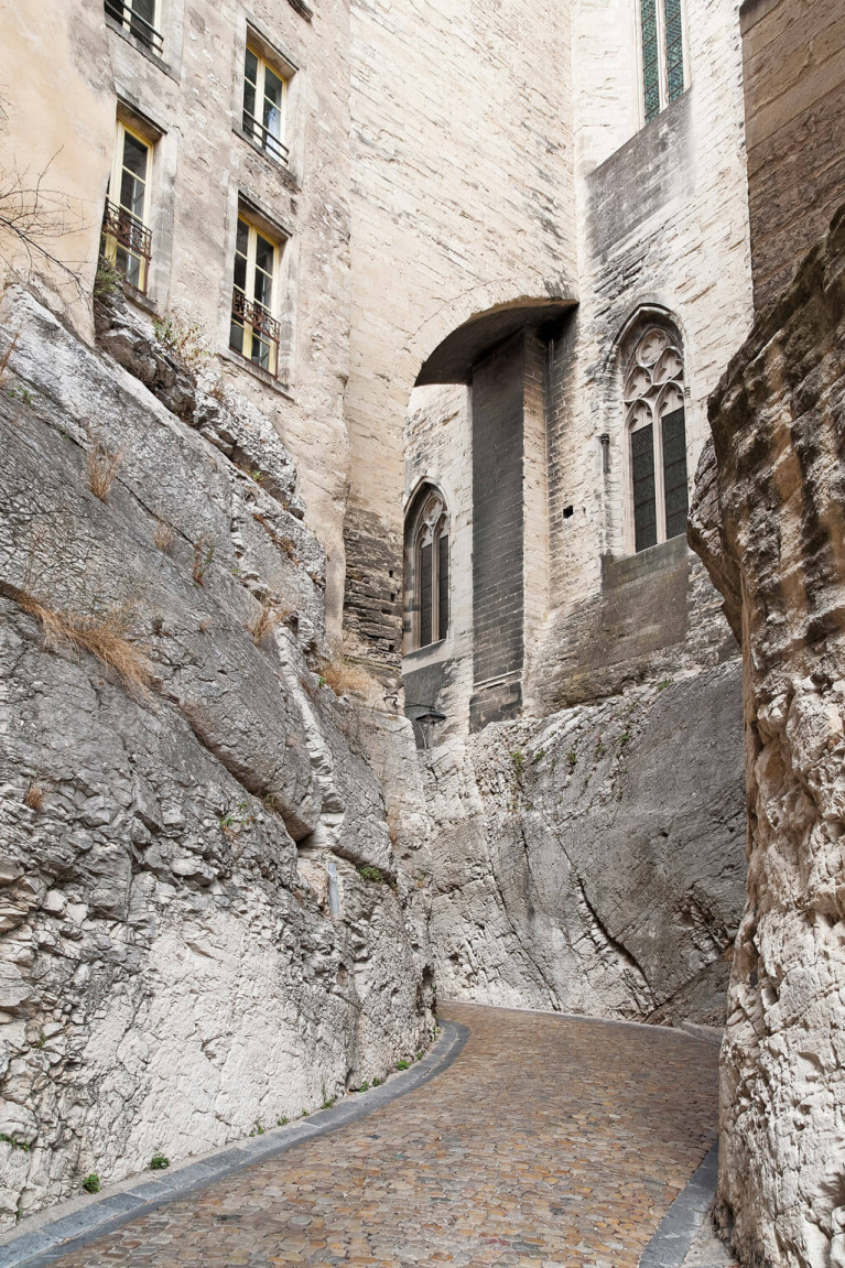 Rugged stone facade of ancient French buildings near the exquisite Avignon Hôtel Particulier, a beautifully restored 19th century mansion in the heart of Avignon’s historic center - Haven In. #frenchchateau #provence #frenchcountry #restoredchateau #southoffrance #aivgnon