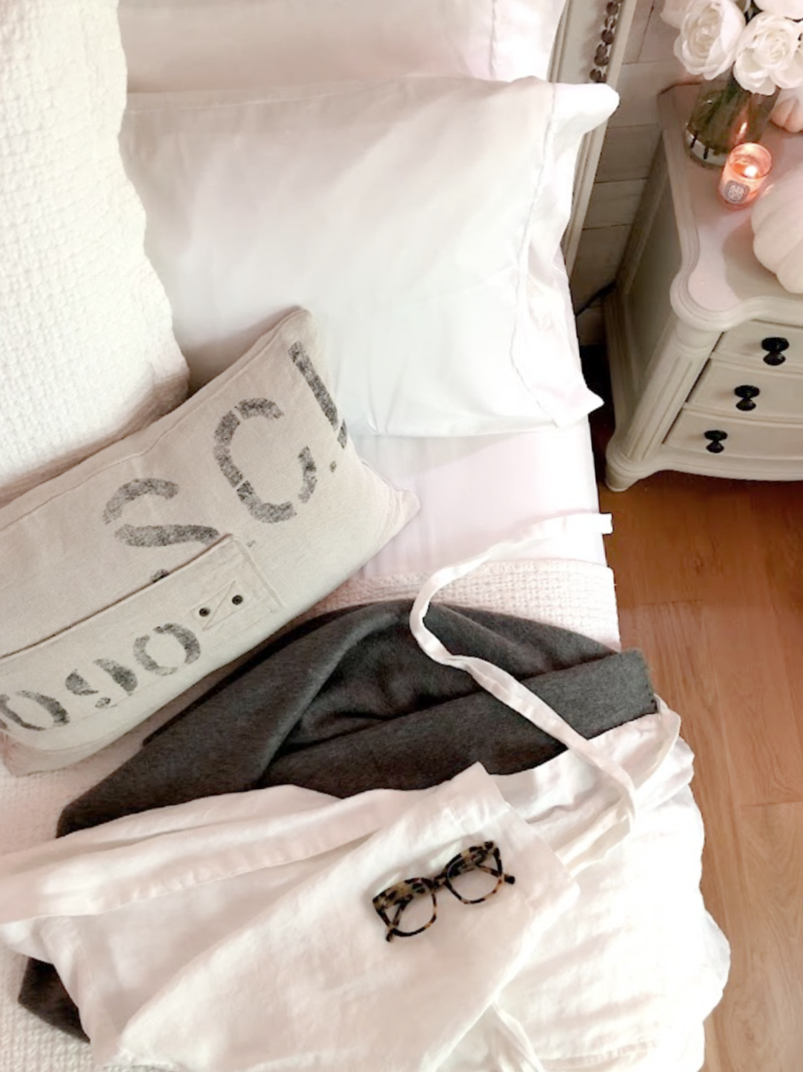 Hello Lovely's neutral white cozy bedroom in fall with Nollapelli sheets, white linen robe, cashmere throw, and Warby Parker frames.