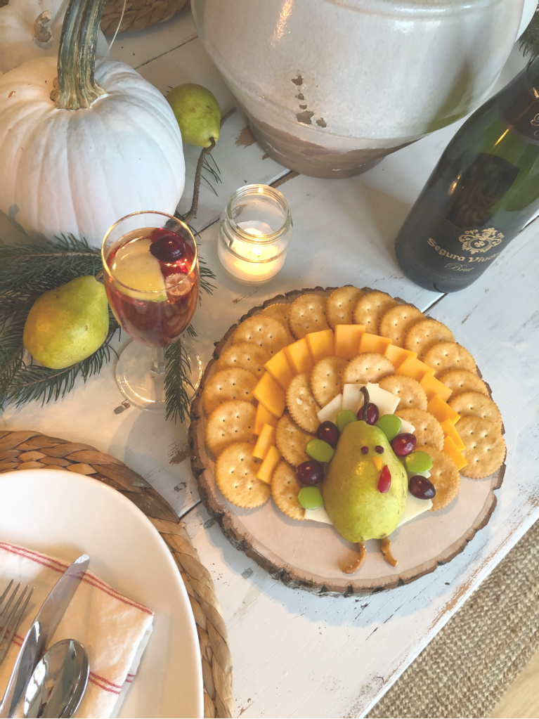 Silly pear turkey on a cheese board for Thanksgiving - Hello Lovely Studio. #thanksgivingrecipes #thanksgivingtable