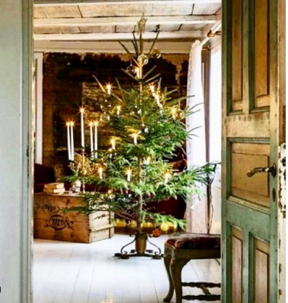 Swedish Christmas tree and candles in an old home with vintage weathered door - Portobello Design. #swedishchristmas #scandichristmas #holidaydecor