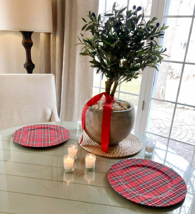Christmas red plaid chargers and a ribbon round my potted olive tree - Hello Lovely.
