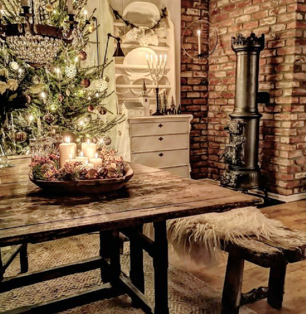 Rustic Scandi Christmas dining room with farm table, wood stove, and brick - Vibekedesign. #scandichristmas #farmhousechristmas