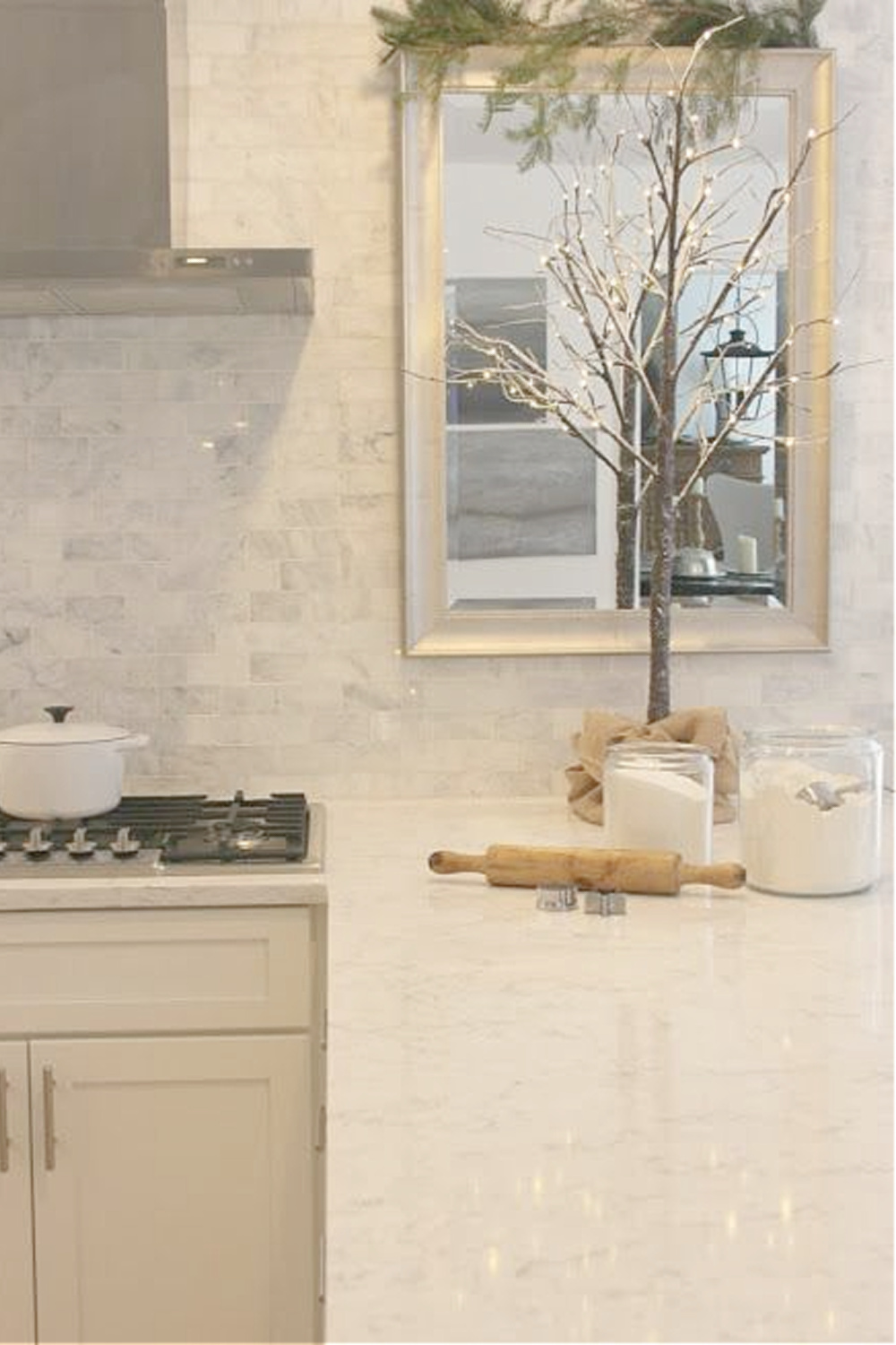 Simple Christmas decor in my white kitchen - a winter tree with little white lights and a burlap base on the counter. #hellolovelystudio #whitechristmas #simplechristmas #christmasdecor