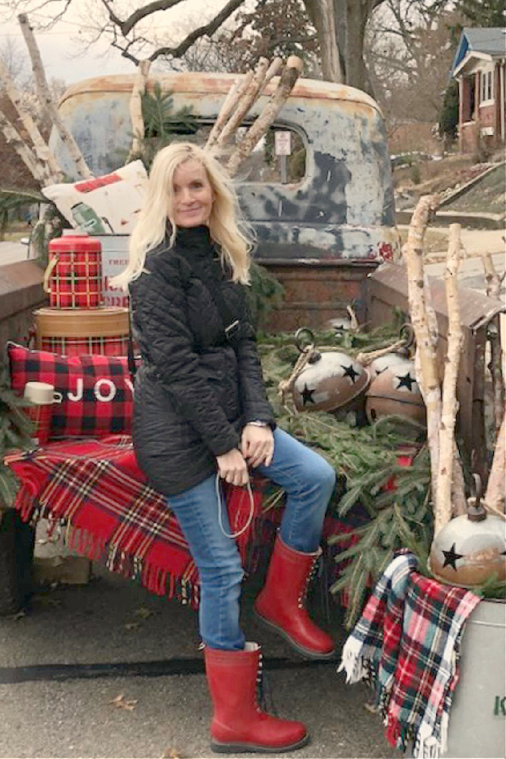 Michele of Hello Lovely on a vintage pickup decorated for Christmas with farmhouse plaids.