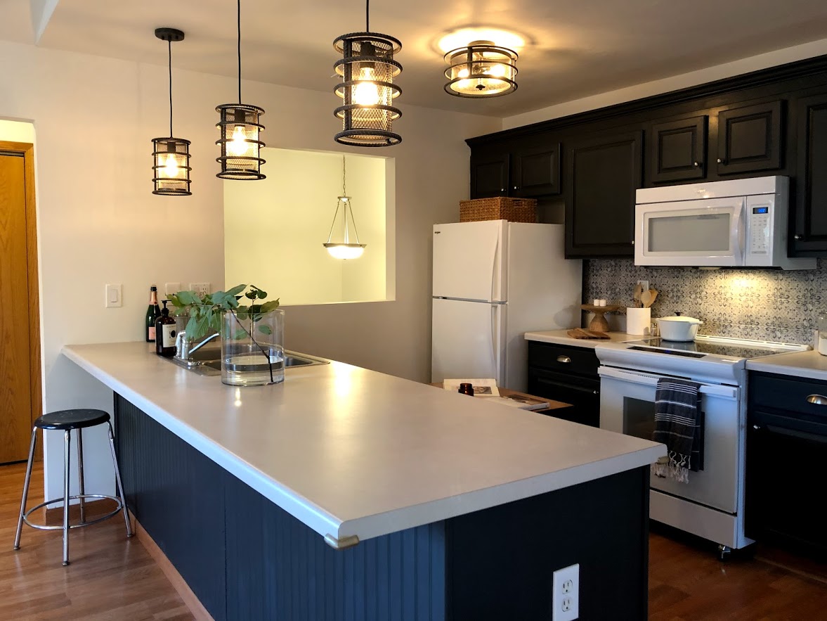 Crisp white walls contrast with the deep dark blue/gray cabinets (Sherwin Williams Carbonized).