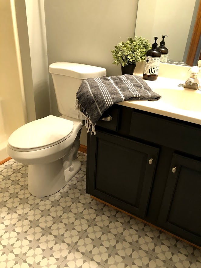 Vanity in the bathroom was painted Sherwin Williams carbonized which provides a nice contrast with the light and bright tiled floor.