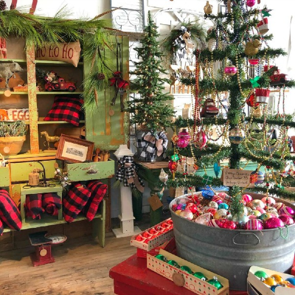 Magnificent vintage Christmas decor inside Trove Vintage with green 1860s cupboard filled with red buffalo check - Hello Lovely Studio. #hellolovelystudio #farmhousechristmas #countrychristmas #christmasdecor #primitives