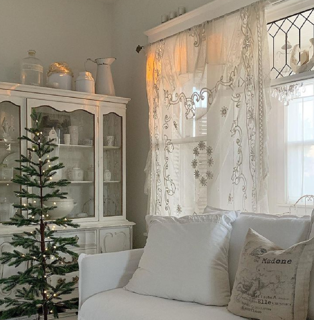 Nordic French Christmas decor in a living room with sheer curtains and all white decor - My Petite Maison. #frenchnordicchristmas #scandichristmas #swedishchristmas