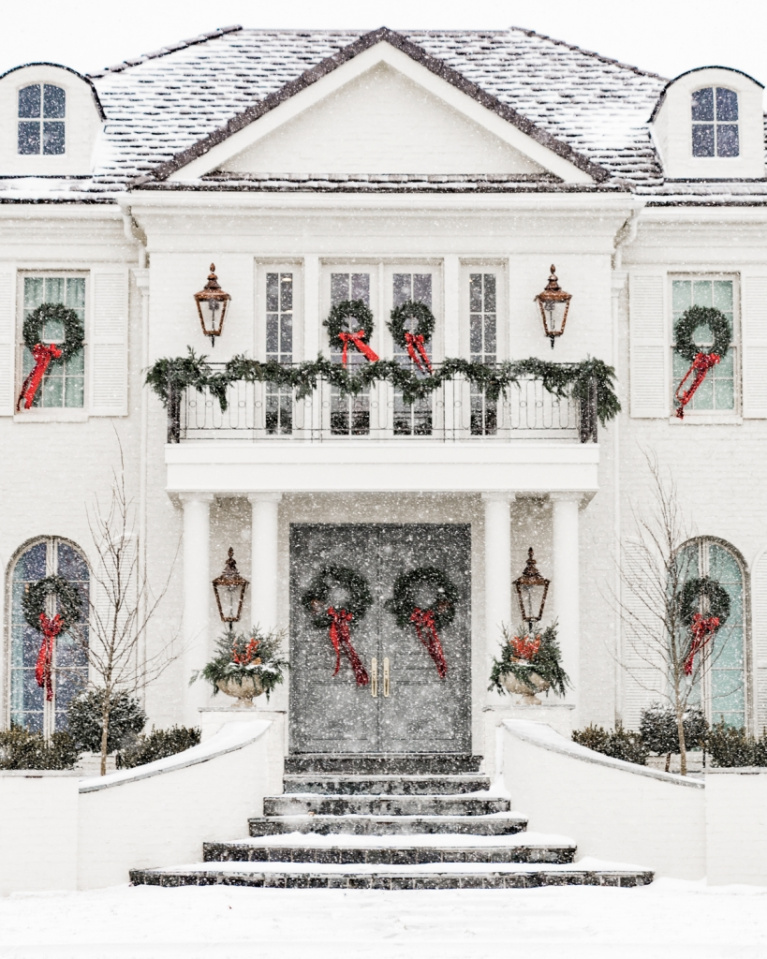 Rach Parcell's magnificent white grand traditional house exterior decorated for Christmas with fresh wreaths in every window.