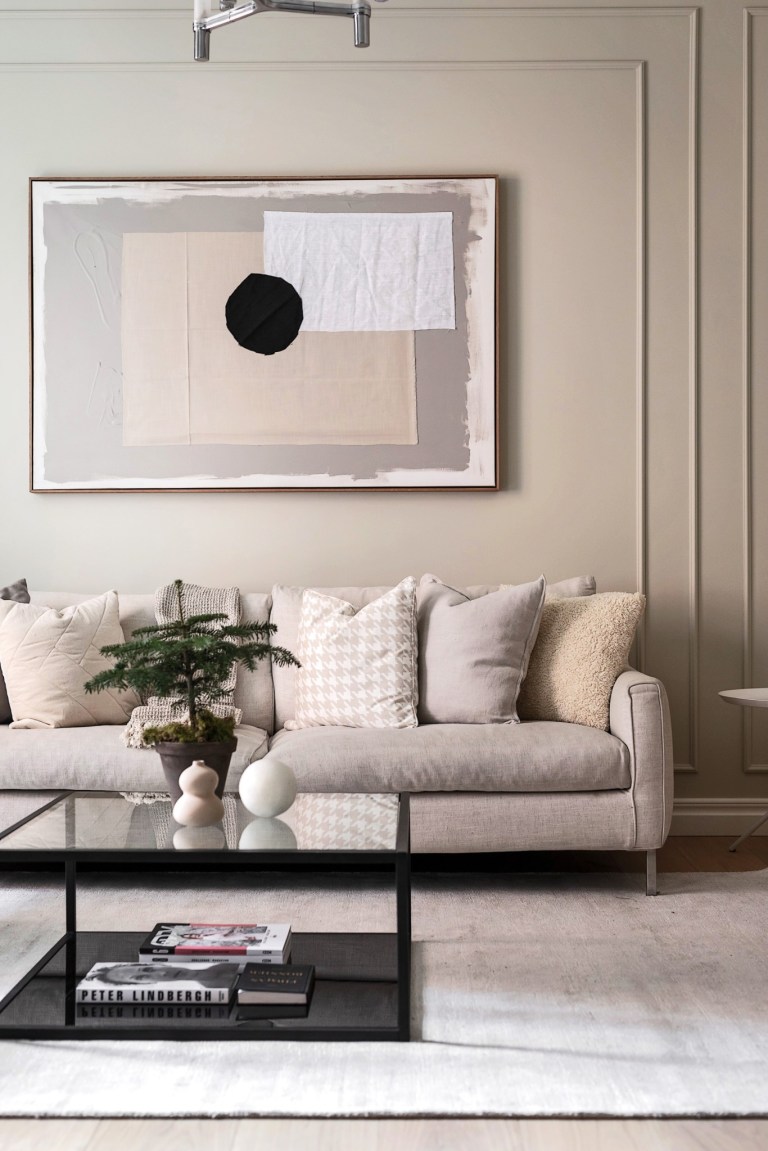 Cozy neutral beige living room in a Swedish home with modern art and calm design style - PlaneteDeco.