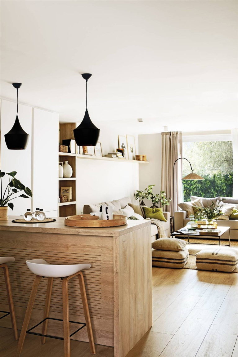 An open kitchen in Barcelona with calm, zen, natural modern style and black pendants over breakfast bar - Pia Capdevilla.