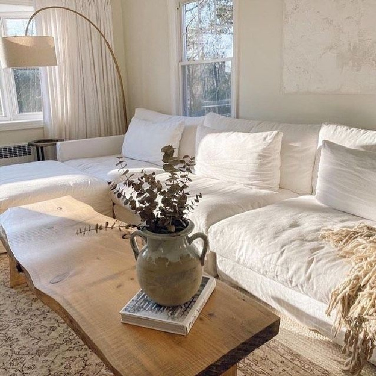 Cozy comfy zen living room with white sectional, modern floor lamp and rustic wood coffee table - @visionityourself.