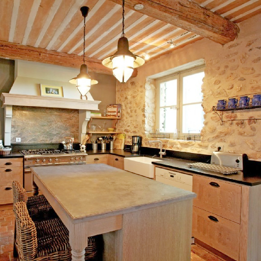 French farmhouse kitchen in Provence with stone walls, wood beam ceiling, and terracotta floors - Bonnieux via Haven In. #frenchkitchen #oldworldkitchen