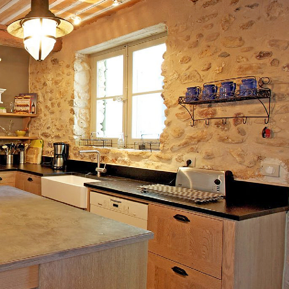 French farmhouse kitchen with limestone walls and farm sink. #frenchkitchen #provencekitchen #frenchfarmhouse