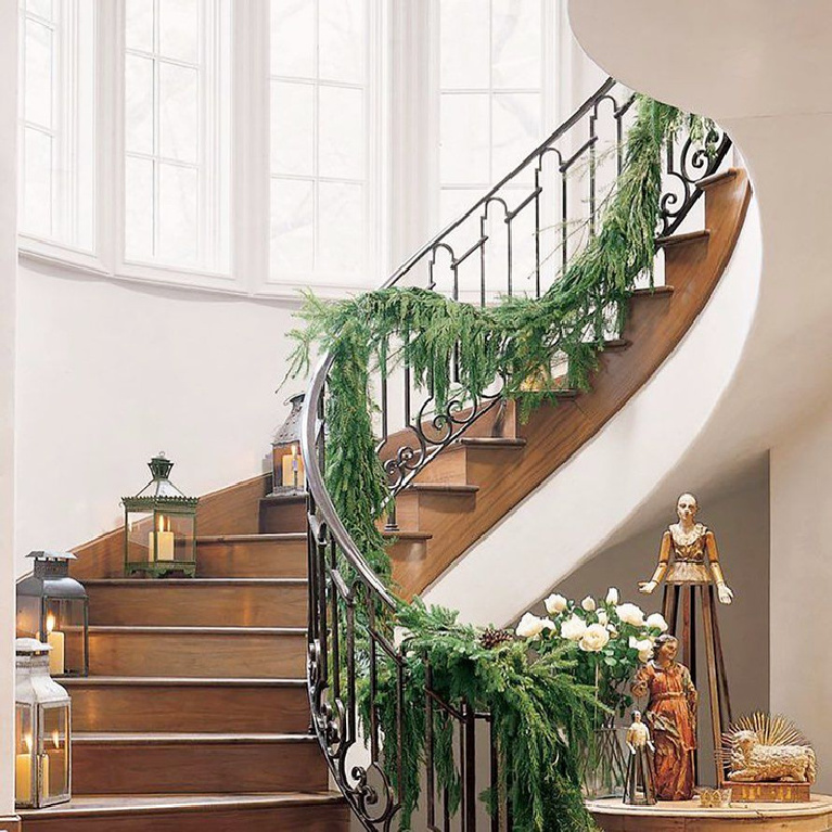 Elegant Christmas garland on a beautiful staircase with wrought iron railing - Cindy Hattersley.