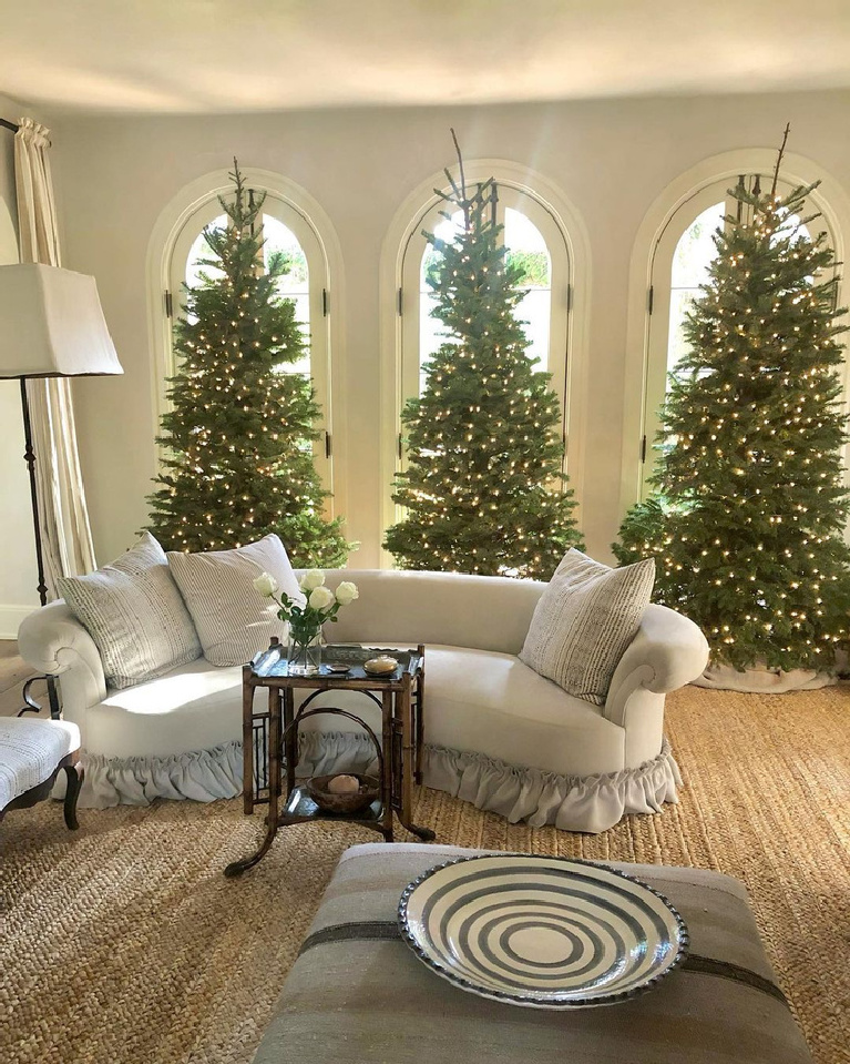 A trio of Christmas trees and arched windows in the lovely living room of Pamela Pierce of Milieu.