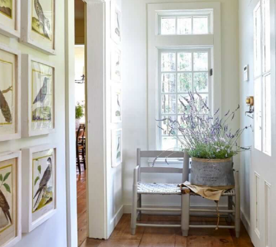 Framed prints and a basket of lavender in a beautiful country house hall - Nora Murphy.