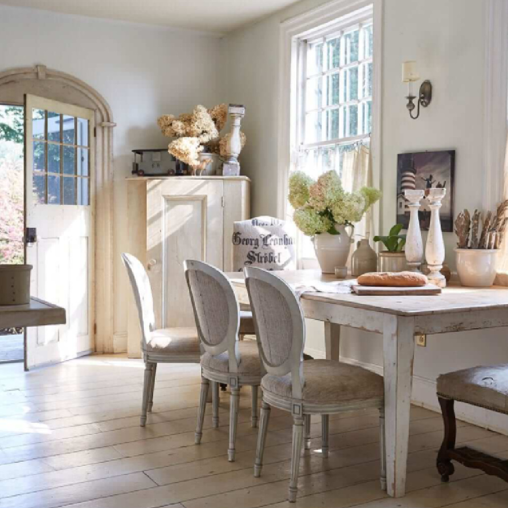 French country style dining area with farm table, pale colors, and antiques in Nora Murphy Country House book.