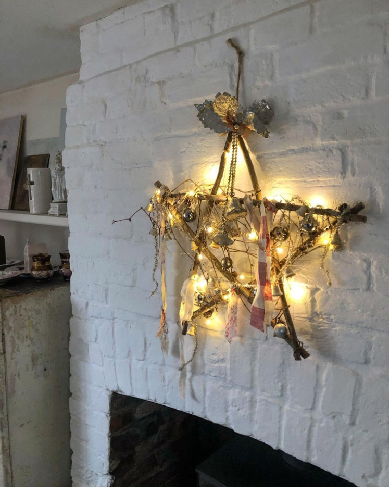 Charming and rustic Christmas star made from twigs against a white brick hearth - MySimpleHome. Enjoy Glorious 2020 Holiday Decorations & Inspiring Quotes for a new year!